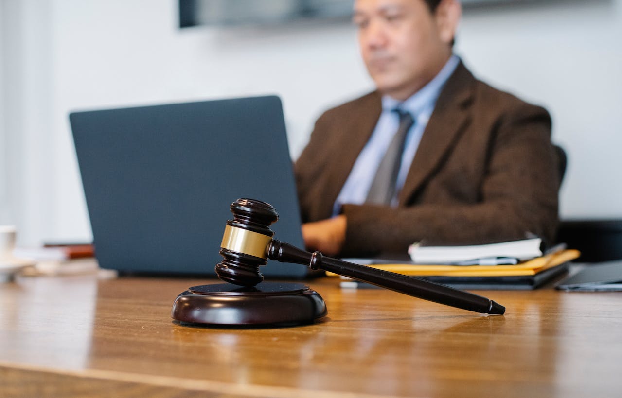 Crop Asian judge working on laptop in office