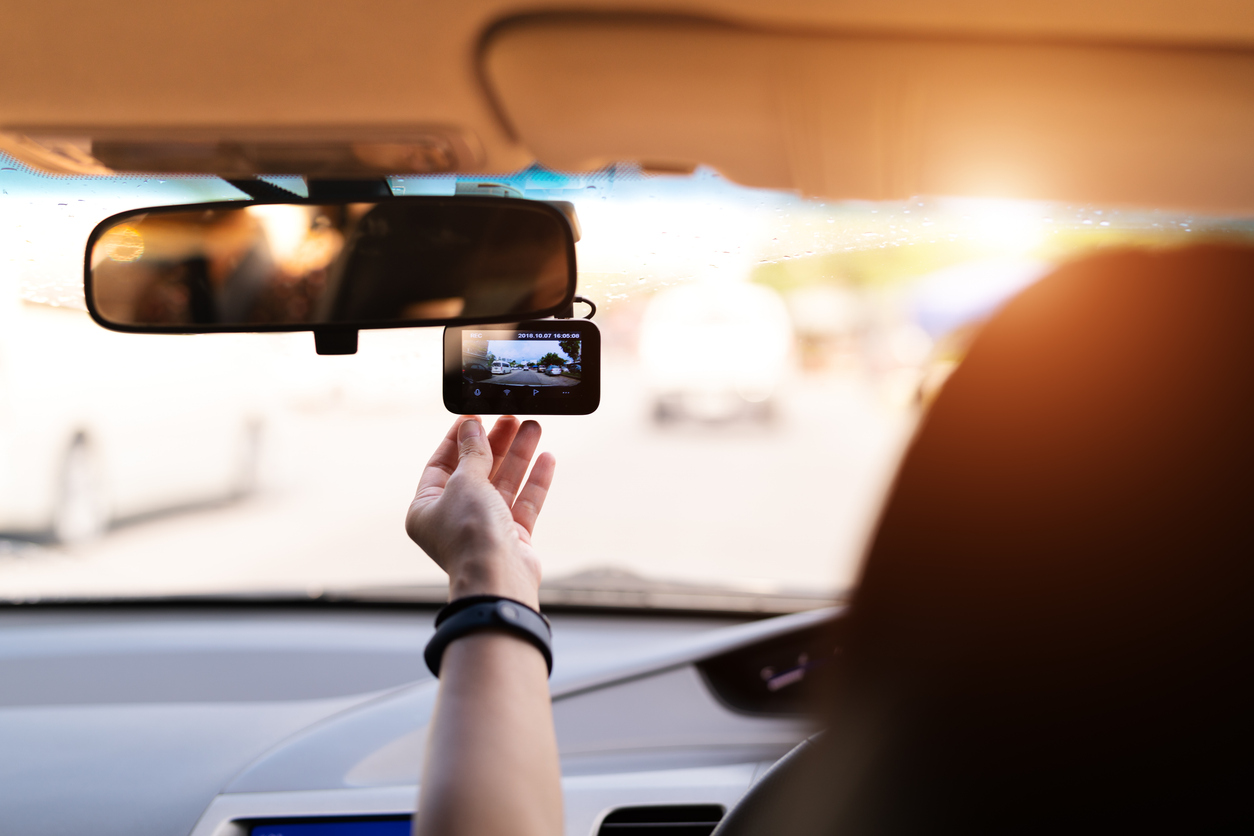 sun glare, woman set video recorder next to a rear view mirror