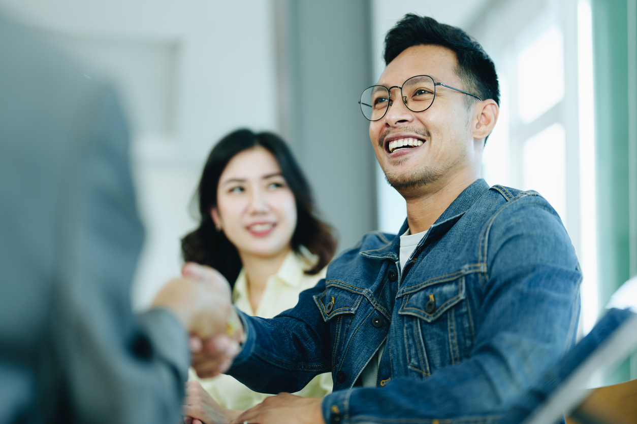 the bank's mortgage officers shake hands with customers to congratulate them after signing a housing investment loan agreement