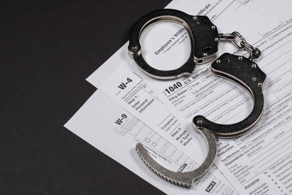 income,tax,return,documents,and,handcuffs.,tax,evasion,,crime,and