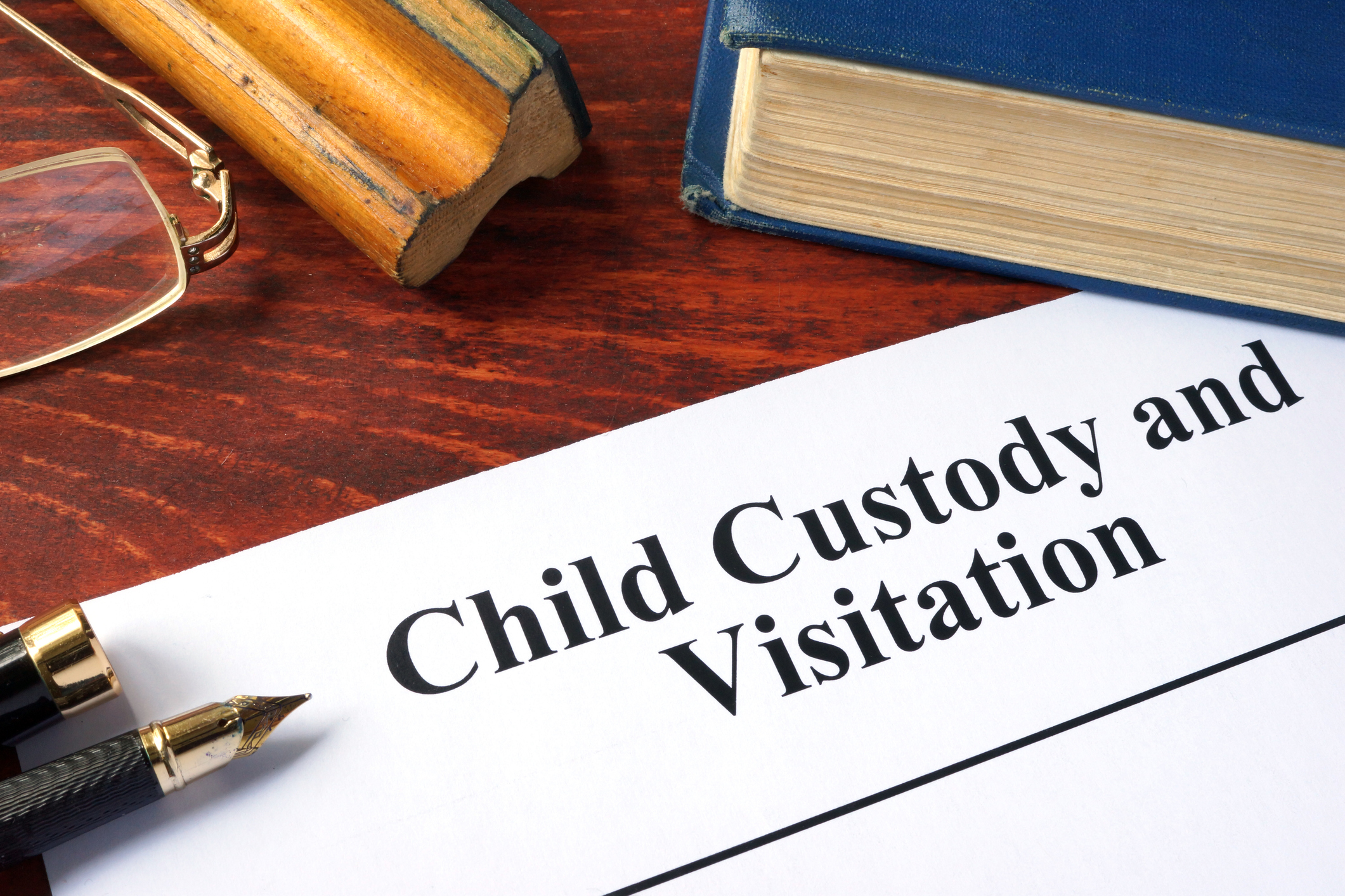 child custody and visitation written on a paper and a book.