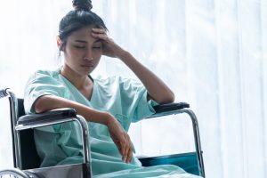 serious patient sitting on wheelchair in hospital.