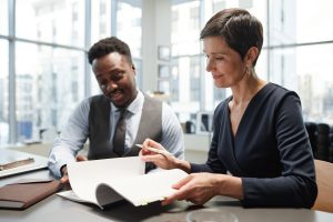 elegant mature businesswoman signing documents with colleague in office