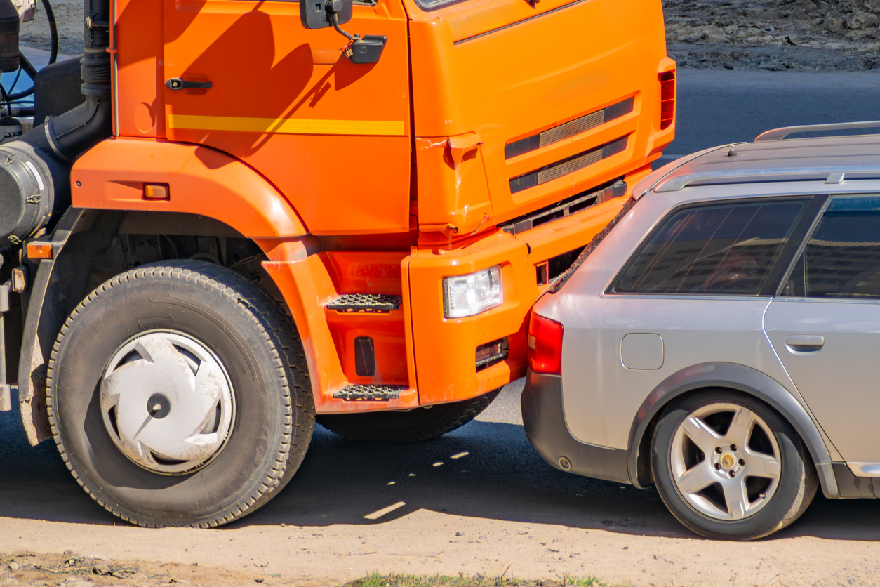 car accident between an orange truck and a passenger car. traffic accident