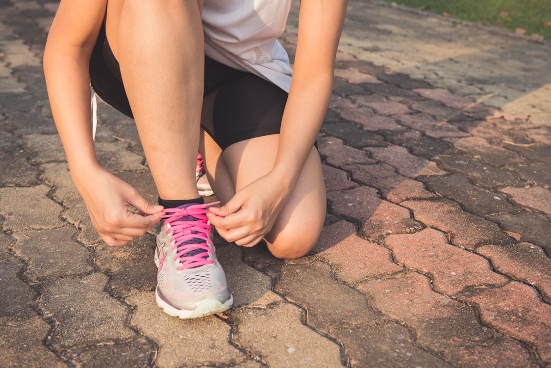 A woman tying her shoelaces before going for a run.