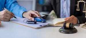 justice statue hammer and car on wooden background judge hammer with toy car and papers car auction close up, car keys on table in office