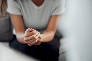 cropped shot of an unrecognisable woman sitting alone and feeling anxious during her consultation