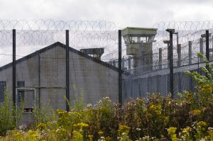 watchtower behind barbed wire fences at a uk prison